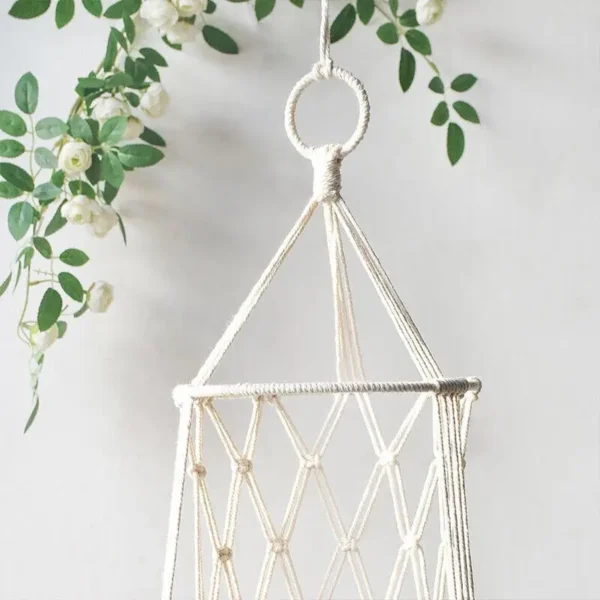 Macrame pet hammock nest basket with fringe detail, styled in a cozy home corner