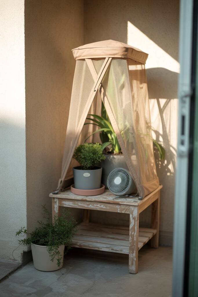 Vertical 2:3 grouping of indoor plants covered by an upside-down pop-up mesh hamper; small USB fan clipped on; saucer under t